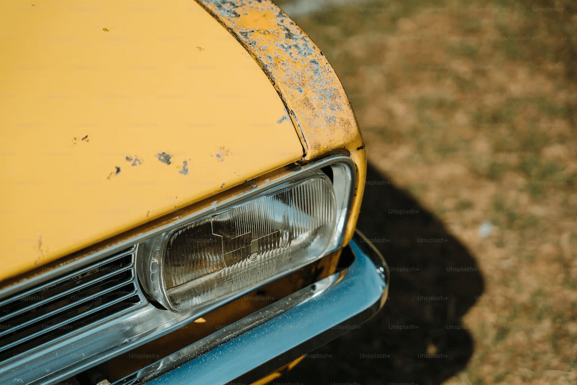 A close up of the front of a yellow car